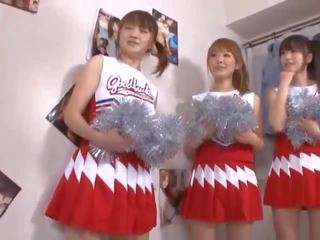 Kolme iso tiainen japanilainen cheerleaderit jakaminen kalu